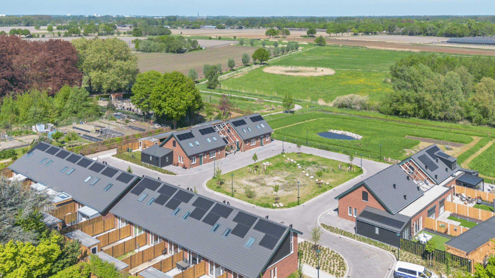 Woonblokken van Antoniuserf in Keldonk rond een groene ruimte met schuurarchitectuur.