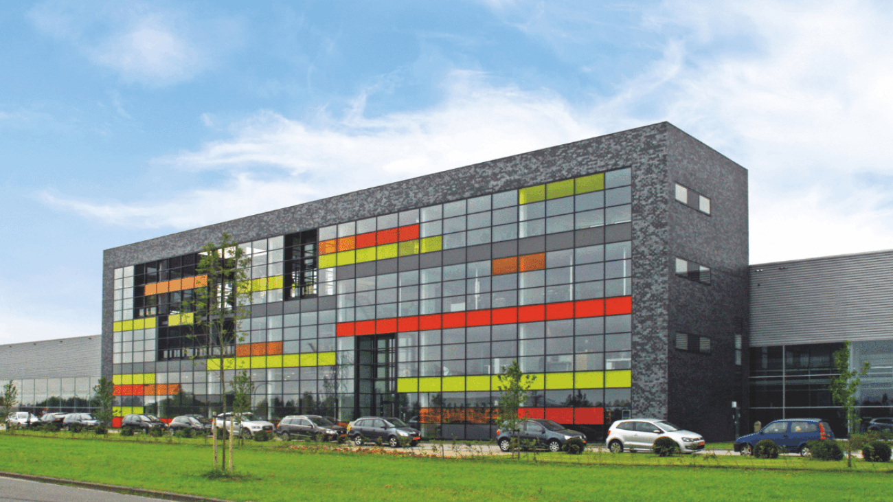 Gevel van Naber Plastics Waalwijk met grote glaswand die het productieproces en het compacte kantoor aan de voorkant toont.